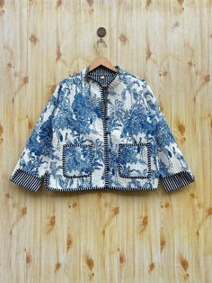 a blue and white jacket hanging on a wooden wall