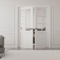 an empty room with white walls and two chairs in front of the open door that leads to another room