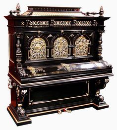 an ornate black and gold organ with intricate carvings on the front, side and sides