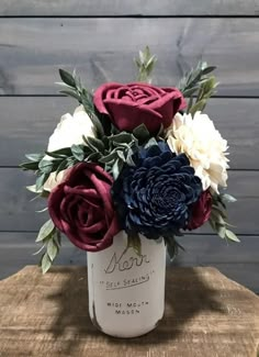 a vase filled with flowers sitting on top of a wooden table