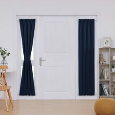 a white door with blue curtains and a wooden chair in front of it on a hard wood floor