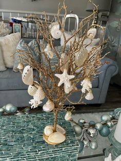 a christmas tree decorated with seashells and starfish on a table in a living room