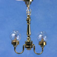 a brass chandelier with three glass globes hanging from it's sides