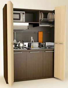 a small kitchen with an open door leading to the sink and microwave oven in it