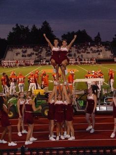 the cheerleaders are doing stunts for the team on the sidelines at night