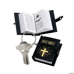 an open bible and keychain with a cross on it