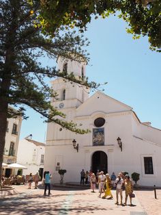 people are standing in front of a white church