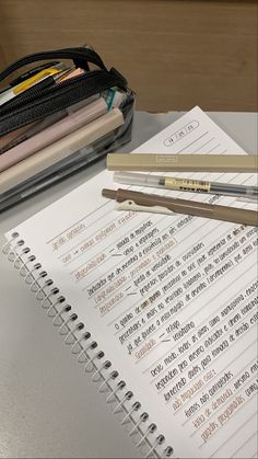 notebooks and pencils sitting on top of a desk next to an open binder