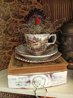 a stack of books with a cup and saucer on top