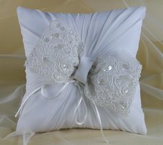 a white wedding ring pillow with lace on it