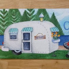 a painting of a camper parked in front of a lake with the words happy camper written on it