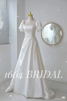 a white wedding dress on display in front of a mirror with the words bridal