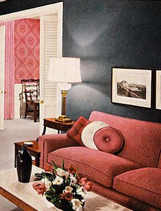 a living room with blue walls and red couches in front of the door to another room