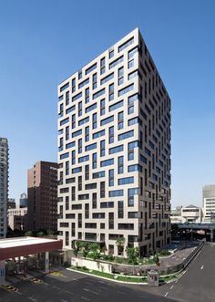 a large building with lots of windows on top of it's sides in the middle of a city