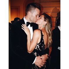 a man in a tuxedo kisses a woman's face at an event