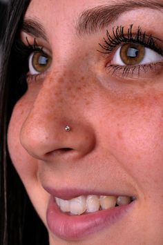 a close up of a woman with freckles on her nose and eye lashes