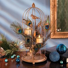 a birdcage filled with candles sitting on top of a table next to ornaments