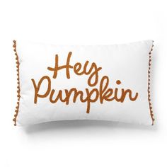 a white pillow with the words hey pumpkin printed on it and pom - poms