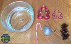 some cookie cutters and candy canes on a wooden table next to a glass jar