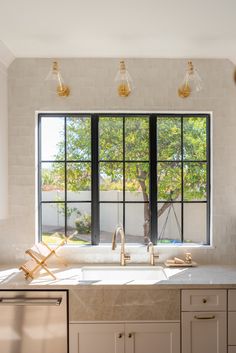 a kitchen with an open window, sink and dishwasher