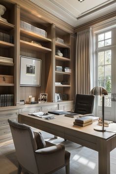 a home office with built - in bookcases and desk, along with two chairs