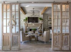 an open living room with french doors and chandelier