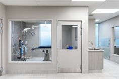 an empty hospital room with medical equipment in the window and on the wall, as well as two sinks