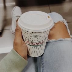 a person sitting on the floor holding a cup of coffee