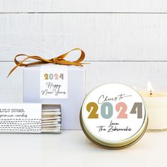 a candle and some matches sitting on a table next to a box with the year 2021