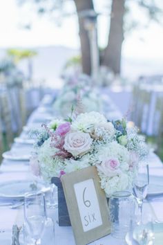 the table is set with flowers and place cards