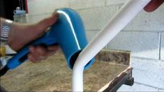 a person is using a blue and white hose to fix a sink faucet