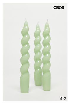 three green candles sitting next to each other on top of a white surface with the words osso written above them