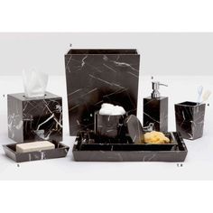 black marble bathroom accessories including soap, toothbrush holder and tissue dispenser