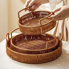 two wicker baskets are stacked on top of each other, one is holding scissors