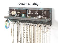 a wooden shelf with jewelry hanging from it's sides and the words ready to ship above it