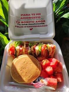 there is a sandwich and some watermelon on the plate in this lunch box