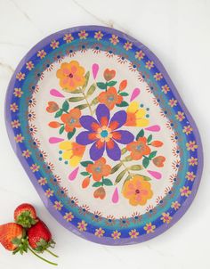 a plate with flowers on it next to strawberries