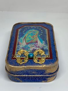 a blue and gold box with a painting on it