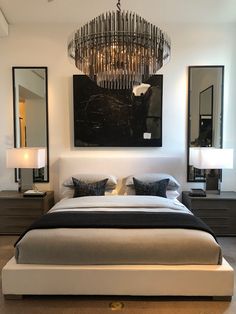 a bedroom with a large chandelier above the bed