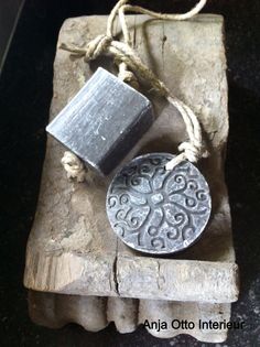 a piece of metal sitting on top of a wooden block next to a string and rope