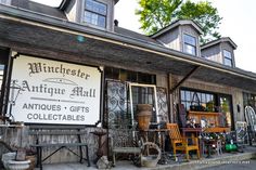 an antique store with lots of antiques on the front and side of it's building