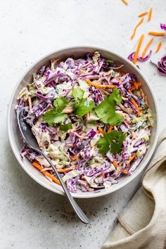 a white bowl filled with coleslaw and garnished with cilantro