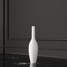 a white vase sitting on top of a black table next to a gray wall and floor