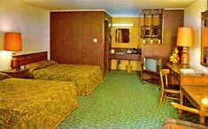 two beds in a hotel room with green carpeting and lamps on the nightstands