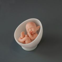 there is a small plastic baby in a bowl