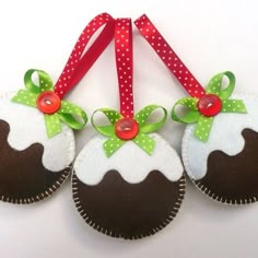 three felt christmas ornaments with bows and ribbons on the front, two are brown and one is white