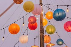 many colorful lanterns are hanging from a pole