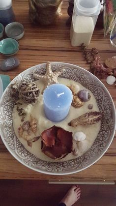 a plate with shells and a candle on it