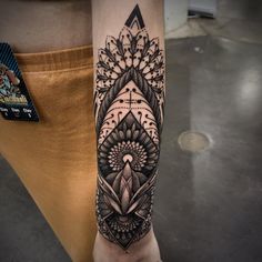 a woman's arm with a tattoo on it and an intricate design in the middle