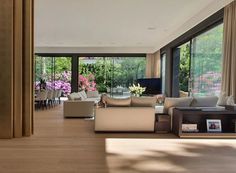 a living room filled with furniture and lots of windows next to a wooden floor covered in flowers